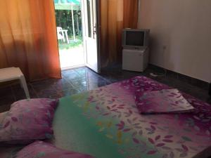 a bed in a room with a tv and a bed sidx sidx at Bungalow Eforie Nord in Eforie Nord +7 photos
