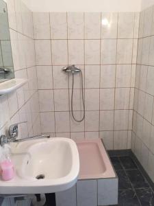 a white bathroom with a sink and a shower at Bungalow Eforie Nord in Eforie Nord