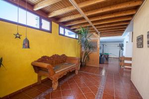 a room with a bench and a yellow wall at ITY House in Playa Honda