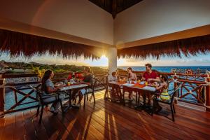 un groupe de personnes assises à table dans un restaurant dans l'établissement Occidental at Xcaret Destination - All Inclusive, à Playa del Carmen