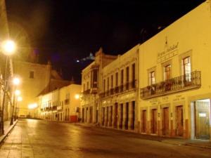 an empty city street at night with buildings at Hotel Reyna Soledad in Zacatecas