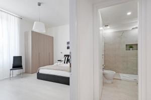 biała sypialnia z łóżkiem i łazienką w obiekcie White Flat Termini w Rzymie