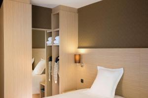 a bedroom with a white bed and white walls at Escale Oceania Saint Malo in Saint Malo
