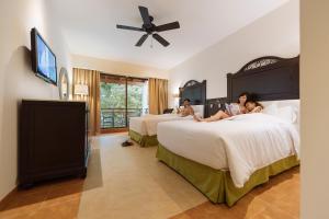 three people laying on beds in a hotel room at Occidental at Xcaret Destination - All Inclusive in Playa del Carmen