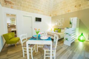 a living room with a table and a bedroom at Dimora Antica Via MiLord in Monopoli