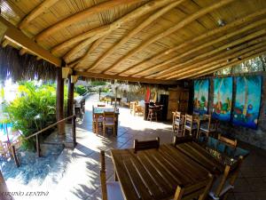 a patio with tables and chairs under a wooden pergola at Hotel Grandmare & Bungalows in Máncora