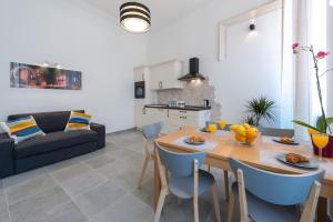 una cucina e un soggiorno con tavolo in legno e sedie blu di Nikili apartment Old City a Dubrovnik