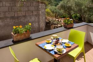 une table avec des tasses et des soucoupes sur un balcon dans l'établissement Appartamento degli Ulivi 2, à Sant'Agnello 3 autres photos