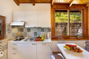 une cuisine avec des armoires blanches et un bol de fruits sur un comptoir dans l'établissement Appartamento degli Ulivi 2, à Sant'Agnello