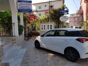 a white car parked next to a building at Captain Georgio Apartments in Poros