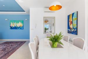 a white dining room with a white table and chairs at Villa Sveti Petar - with heated pool and outdoor jacuzzi in Opatija