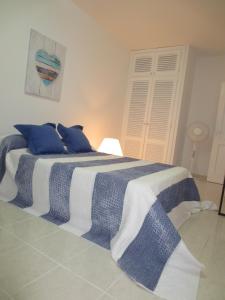 Un dormitorio con una cama azul y blanca con almohadas azules en Ocean house & perfect for you en Adeje