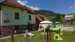 a fence in front of a house with a playground at Apartmán u Benkov in Lúčky