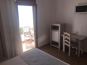 a small room with a bed and a tv at Hotel Almadrabeta in Zahara de los Atunes