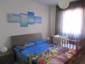 クストナーチにあるCasa Vacanza Tra Cielo e Mareの子供用ベッドルーム(青いベッド1台、ベビーベッド1台付)