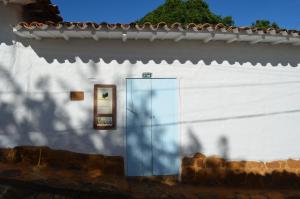 a white building with a glass door on it at Albahaca Hospedaje Tienda in Barichara