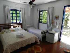 a bedroom with two beds and two windows at Pousada Ypê Amarelo in Itatiaia