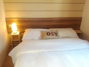 a bedroom with a white bed with a wooden headboard at Les Charmettes Mobilhomes17 in Les Mathes