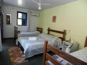 a bedroom with two beds and a window at Pousada Ypê Amarelo in Itatiaia