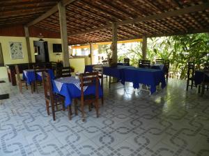 a dining room with blue tables and chairs at Pousada Ypê Amarelo in Itatiaia