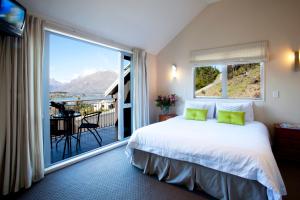 ein Schlafzimmer mit einem Bett und einem großen Fenster in der Unterkunft White Peaks Villa in Queenstown
