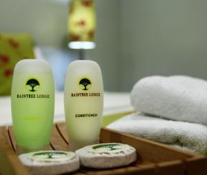 a couple of bottles of moisturizers on a table with towels at Raintree Lodge in Port Moresby