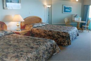 a hotel room with two beds and a table at North Shore Inn in Port Hardy