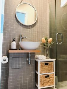 a bathroom with a sink and a mirror at New Market Cozy Room in Auckland