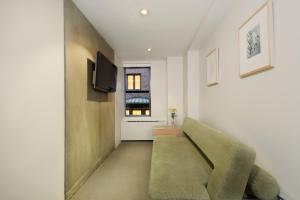 a living room with a green couch and a window at Shoreham Hotel in New York