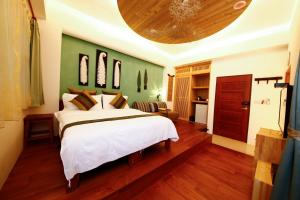 una camera con un letto bianco e una parete verde di Tang Chao B&B a Jiaoxi