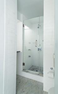 a bathroom with a shower with a glass door at Shoreham Hotel in New York