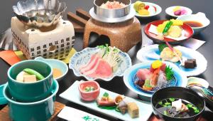una tavola ricoperta di piatti di cibo su un tavolo di Isawa View Hotel a Fuefuki