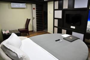 卡来卡Hotel Anandhiram Heritage的客房设有1张带电视的床和1张四柱床。