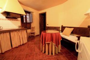 una camera con tavolo e letto e una cucina di La Boticaria Casa Rural Apartamento a Descargamaría