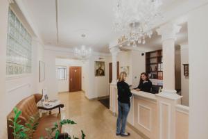 two women standing at a counter in a room at Hotel Cesarski - Kaiserhof in Giżycko