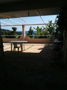 a table and a chair sitting in a patio at Varagoulis Giannis & Lenas Apartments in Paramonas