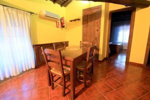 comedor con mesa de madera y sillas en La Boticaria Casa Rural Apartamento, en Descargamaría