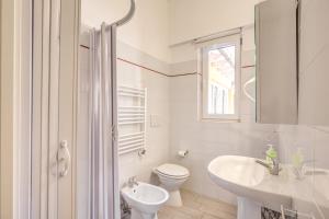 a white bathroom with a toilet and a sink at Relais La Torretta in Rome
