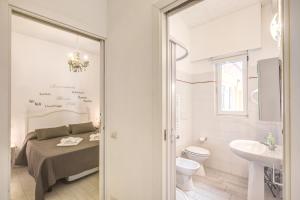 a bathroom with a bed and a toilet and a sink at Relais La Torretta in Rome