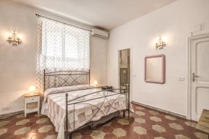 a bedroom with a bed and a mirror and a window at Relais La Torretta in Rome