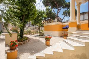 a courtyard with stairs and flowers in pots at Relais La Torretta in Rome