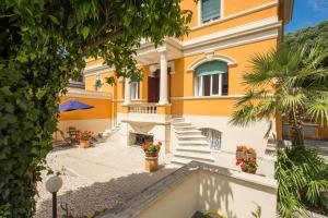 a yellow house with stairs and flowers in a courtyard at Relais La Torretta in Rome