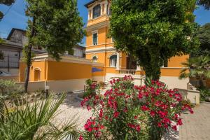 a yellow building with pink flowers in front of it at Relais La Torretta in Rome