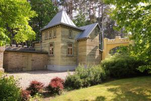 an old house with a turret in a garden at Cottage Dzintars in Jūrmala