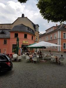 un grupo de mesas y sillas con sombrillas en una calle en Zimmervermietung M.P. en Greiz