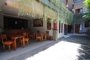 un restaurante con mesas de madera y sillas en un patio en Bubu Inn, en Ubud