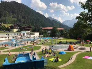 een groep mensen bij een zwembad in een park bij Haus Keti in Riezlern