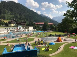 un groupe de personnes à la piscine dans un parc dans l'établissement Haus Keti, à Riezlern