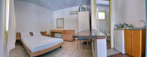 a small bedroom with a bed and a kitchen at Pefka Rooms in Mytilene