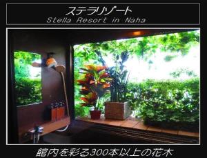 a bathroom with a fish tank in a window at Stella Resort in Naha